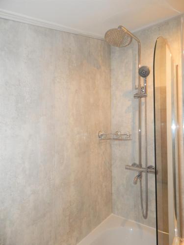 a shower with a glass door in a bathroom at The Saxon Inn in Bishop Auckland