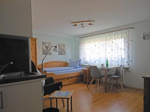 a living room with a table and a bed at Ferienhaus-Heisser-Sand-Whg-2 in Wittdün