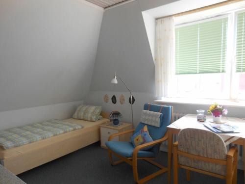 a bedroom with a bed and a table and chairs at Ferienhaus-Heisser-Sand-Whg-5 in Wittdün