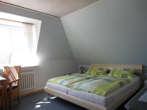 Schlafzimmer mit einem Bett, einem Tisch und einem Fenster in der Unterkunft Ferienhaus "Heißer Sand", Whg 6 in Wittdün