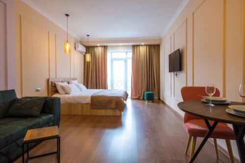 um quarto de hotel com uma cama, um sofá e uma mesa em Iren river side apartments em Tbilisi