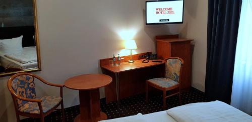a room with a desk and a table and a mirror at Hotel Zeil in Frankfurt/Main