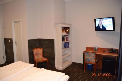 a room with a bed and a desk and a tv at Hotel Zeil in Frankfurt/Main