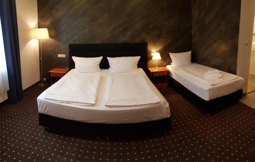 a hotel room with two beds and two lamps at Hotel Zeil in Frankfurt/Main