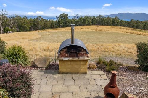 a brick oven in a yard with a field at Manfield Country Bruny Island in Alonnah