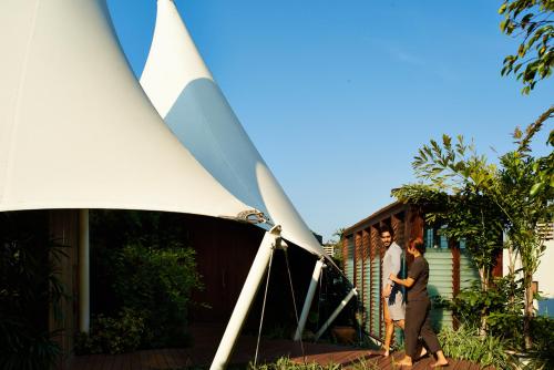 two people are standing next to a wind turbine at Let's Sea Hua Hin Al Fresco Resort in Hua Hin