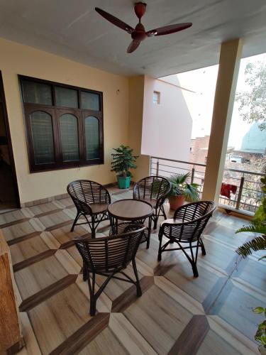a room with a table and chairs and a ceiling fan at Vrinda Apartments in Amritsar