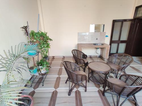 a group of chairs and tables in a room with plants at Vrinda Apartments in Amritsar