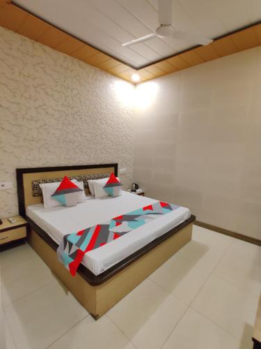 a bedroom with a large bed with red pillows at Vrinda Apartments in Amritsar