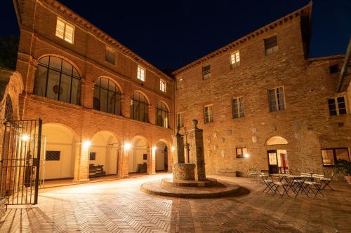 a large brick building with a courtyard at night at Borgo San Lorenzo a Linari in San Rocco a Pilli