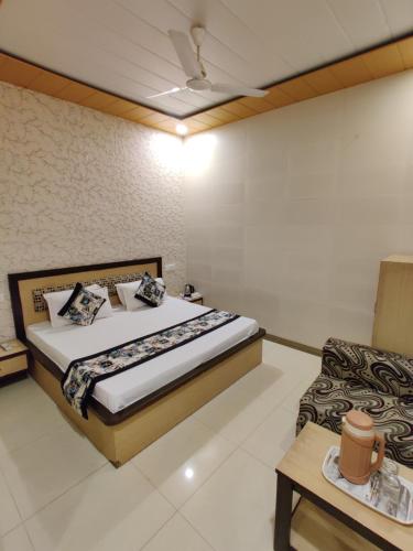 a bedroom with a large bed and a couch at Vrinda Apartments in Amritsar