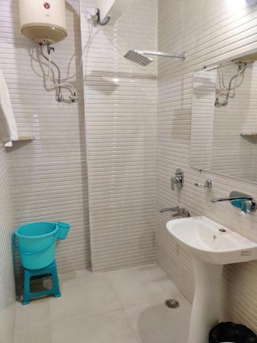 a white bathroom with a sink and a shower at Vrinda Apartments in Amritsar