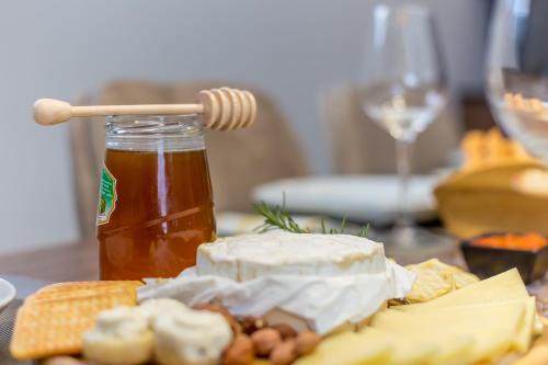 a table with a plate of cheese and a jar of honey at Zerm Holiday House with pool, jacuzzi & sauna - Gorski kotar in Mrkopalj