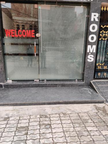 a window of a store with a welcome sign on it at Vrinda Apartments in Amritsar