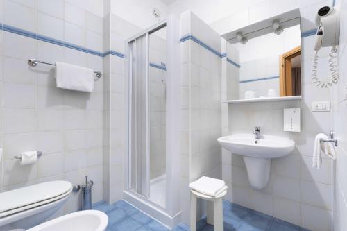 a white bathroom with a toilet and a sink at Tulip Inn Padova in Padova