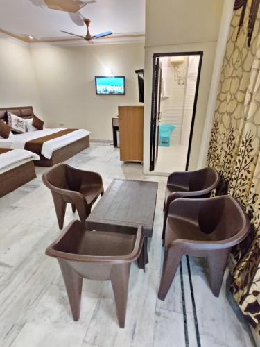 a living room with chairs and a table and a couch at Vrinda Apartments in Amritsar