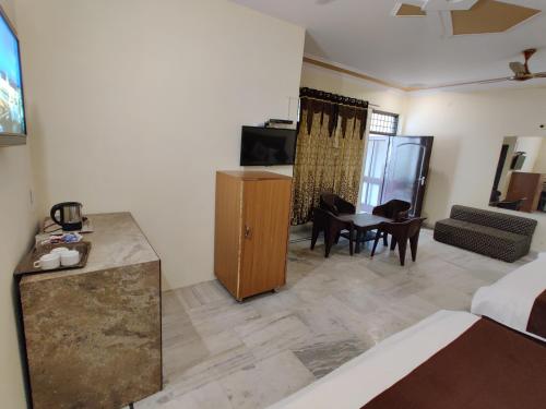 a hotel room with a bed and a living room at Vrinda Apartments in Amritsar