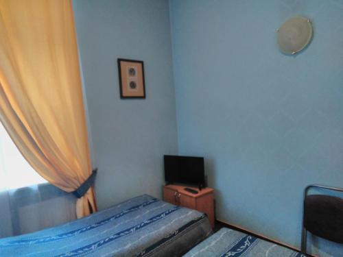 a small bedroom with a bed and a television at Rinaldi at Bolshoy prospect in Saint Petersburg