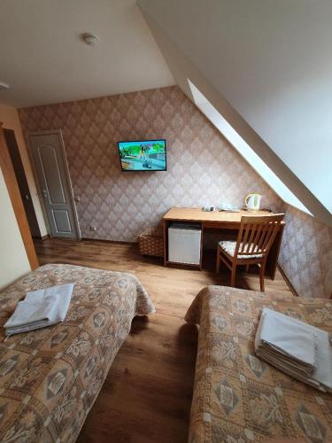 a room with two beds and a table with a television at Raze in Palanga