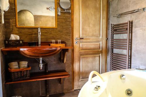 a bathroom with a wooden sink and a tub at B&B Val D'azur in Carqueiranne