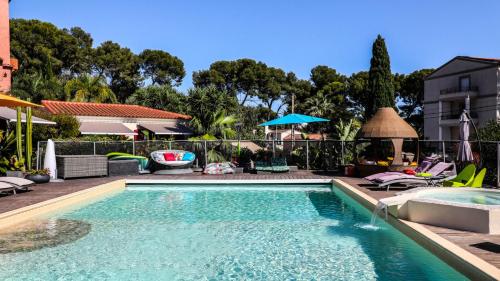 a swimming pool with blue water in a yard at B&B Val D'azur in Carqueiranne