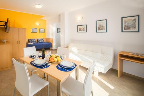 - une salle à manger et un salon avec une table et des chaises dans l'établissement Apartment Gloria Premium, à Poreč