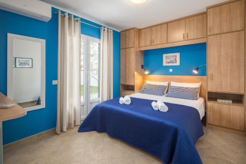 - une chambre bleue avec un lit et des serviettes dans l'établissement Apartment Gloria Premium, à Poreč