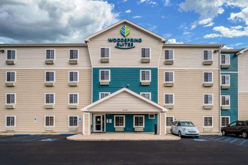 a large building with a car parked in a parking lot at WoodSpring Suites Corpus Christi in Corpus Christi