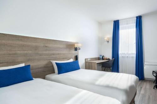 Кровать или кровати в номере Hotel Le Circuit Le Mans
