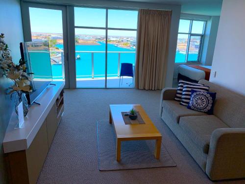 a living room filled with furniture and a window at Wallaroo Marina Luxury Apartment in Wallaroo