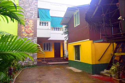 a group of buildings with colorful paint on them at Selvasi Beach Cottage in Auroville