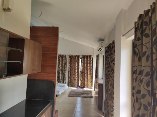 a hallway of a house with a kitchen and a living room at JenJon Karjat Resort - One BHK Premium Chalet with optional SWIMMING POOL in Karjat