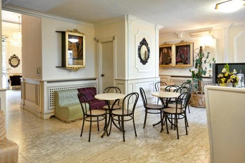 a room with tables and chairs and a fireplace at Hotel Tahiti in Viareggio