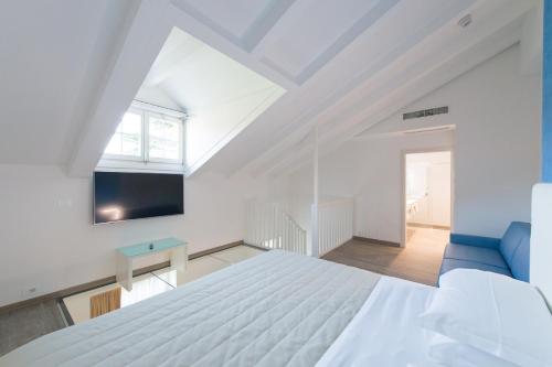 a bedroom with a white bed and a blue couch at Grand Hotel Liberty in Riva del Garda