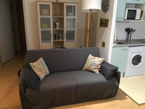 - un canapé avec des oreillers dans le salon dans l'établissement Appartement 5 couchages coquet proche centre, à Cauterets