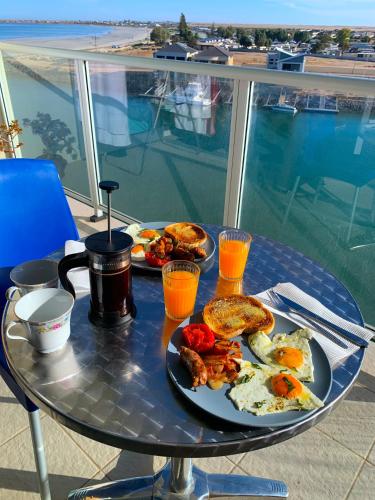 a breakfast table with eggs and toast on a balcony at Wallaroo Marina Luxury Apartment in Wallaroo