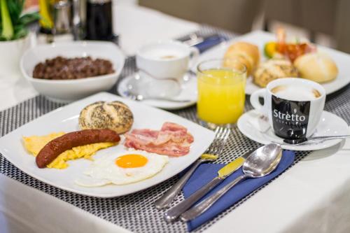 a breakfast table with a plate of breakfast foods and coffee at Royal Airport Hotel in Velika Gorica
