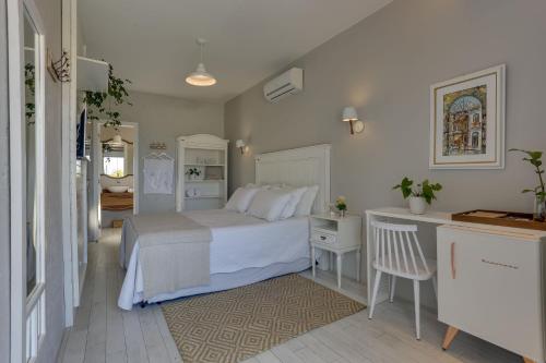 a bedroom with a white bed and a desk at Solar Beach Hotel in Florianópolis