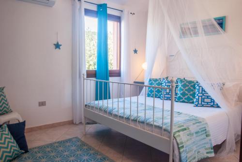 a bedroom with a bed with a canopy and a window at Casa Danilo in San Teodoro
