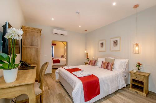 a hotel room with a bed, desk and a lamp at Viewpoint Boutique Living in Xlendi