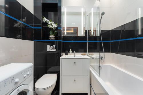 łazienka z toaletą, umywalką i wanną w obiekcie Wilcza 26A by Homeprime w Warszawie