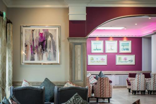 a waiting room with purple walls and chairs at Rathkeale House Hotel in Limerick
