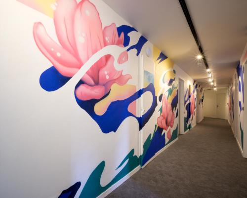 a hallway with a mural of a flower on the wall at L'Outa Hotel Restaurant in Termignon