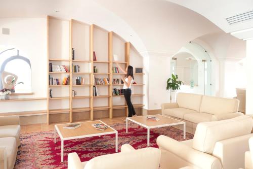 a woman standing in a living room with bookshelves at Tenuta Moreno in Mesagne