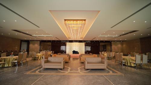 a banquet hall with tables and chairs and a chandelier at THE GRAND VILLAGE in Morādābād