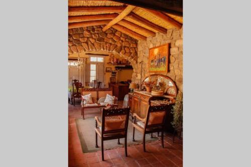 une cuisine et une salle à manger avec un mur en pierre dans l'établissement El Rastrojo - Casa de campo, à Tilcara