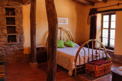 een slaapkamer met een bed met groene kussens bij El Rastrojo - Casa de campo in Tilcara