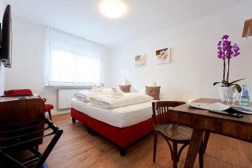 a bedroom with a bed and a desk and a table at Tannmühle Hotel und Restaurant GmbH in Callenberg