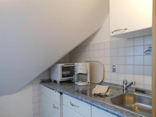 a kitchen with a sink and a microwave at Haus-Nordseemelodie-Wohnung-9 in Wittdün