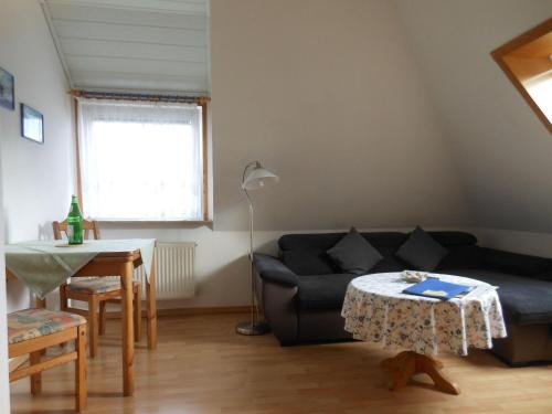 a living room with a black couch and a table at Haus-Nordseemelodie-Wohnung-9 in Wittdün
